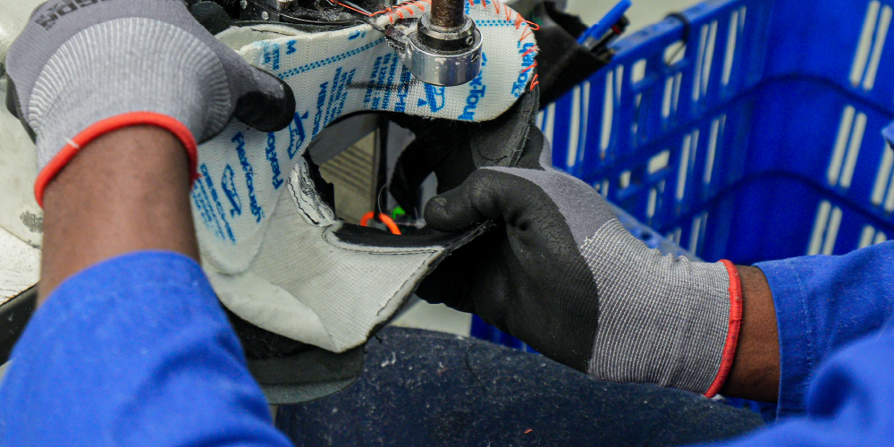 person sewing shoe